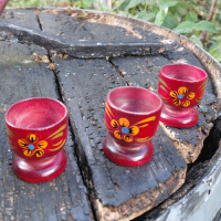 Eierdopjes in houten rek met bloemmotieven