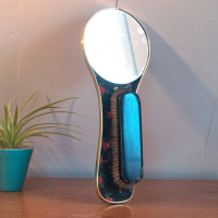 Vintage spiegel met borstel en bloemmotief