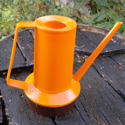 Vintage plastic bloemengieter in oranje en bruin